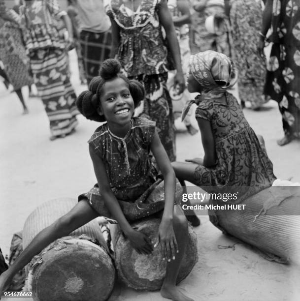 Petites filles jouant du tambour de cérémonie au Gabon, circa 1950.