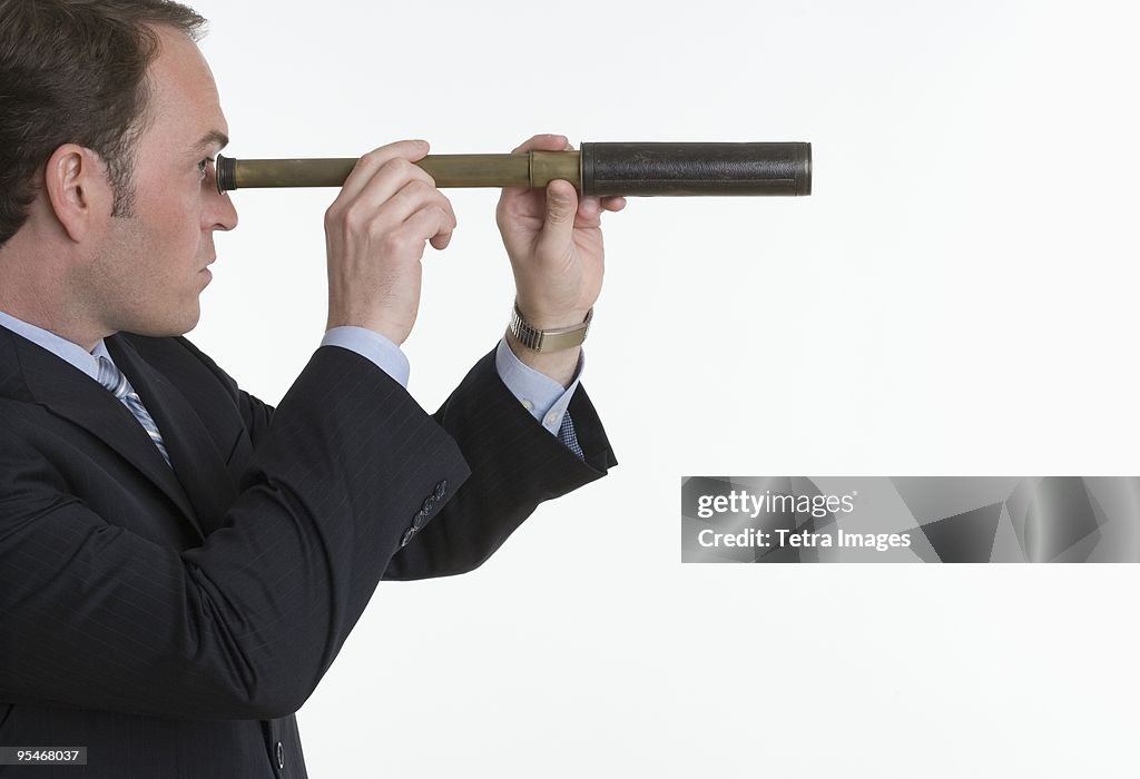 Businessman looking through a periscope