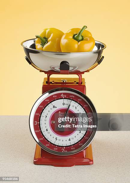 peppers on a scale - gelbe paprika stock-fotos und bilder