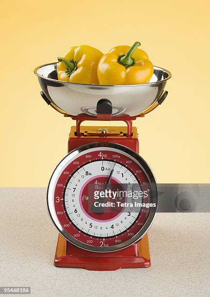 peppers on a scale - poivron jaune photos et images de collection