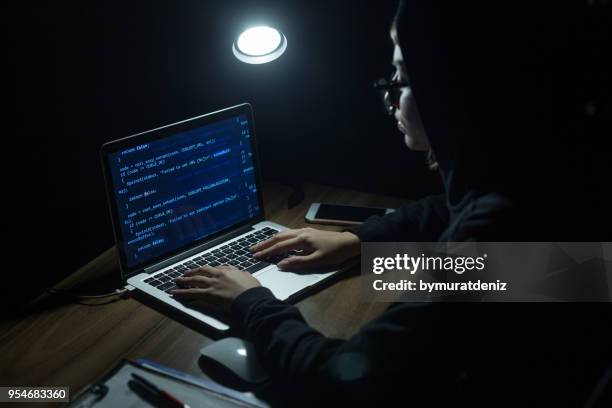 ung kvinna som hooded hacker gör cyberangrepp - säkerhetskod bildbanksfoton och bilder