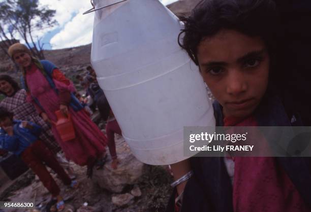 Petite fille transportant un bidon d'eau dans un camp de réfugiés Kurdes Irakiens en Iran, en mai 1991.