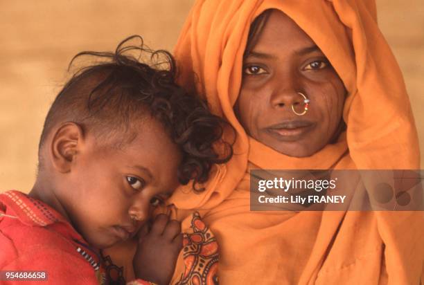 Jeune femme au visage scarifié avec son bébé en Ethiopie, en 1985.