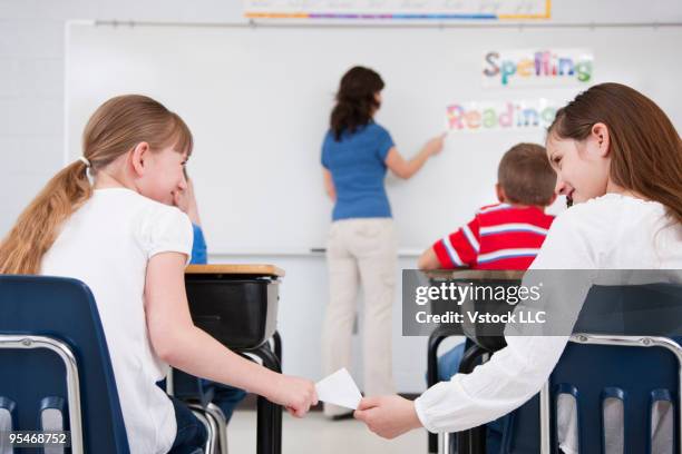 teacher with students - passing notes stock pictures, royalty-free photos & images