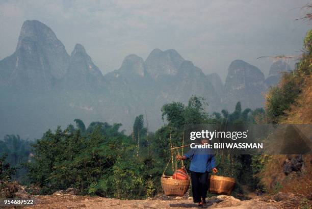 Paysanne portant une palanche près de Xingping, en janvier 1989, Chine.