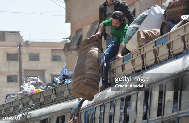 People are seen with their belongings as the second convoy carrying members of the Free Syrian Army and civilians depart from the FSA controlled area...