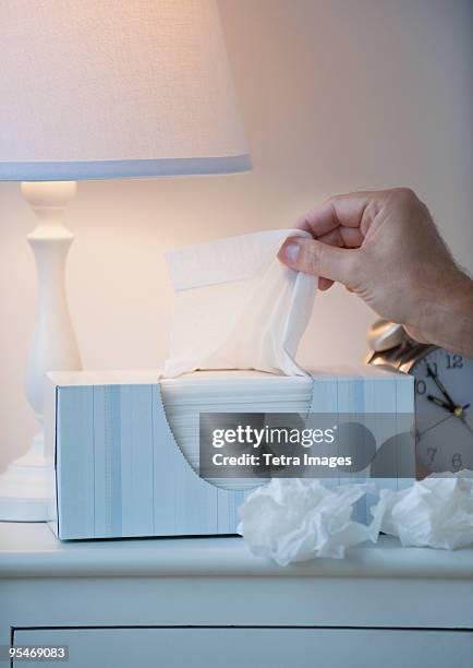 hand pulling tissue out of box - tissue box stock-fotos und bilder