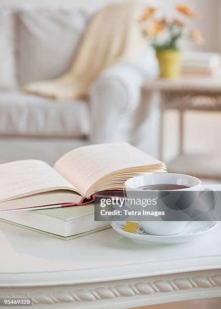 coffee and book on table - coffee table books stockfoto's en -beelden