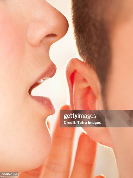 whispering into ear - fluisteren stockfoto's en -beelden
