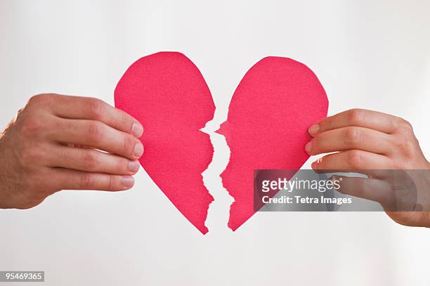 two hands holding broken paper heart - break up 個照片及圖片檔