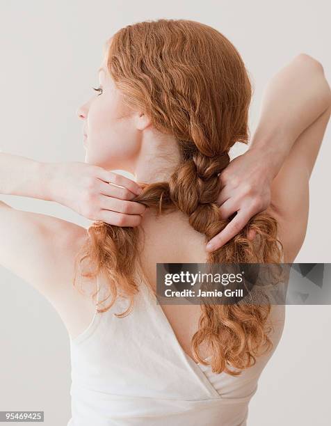 woman fixing hair - curly hair back stock pictures, royalty-free photos & images