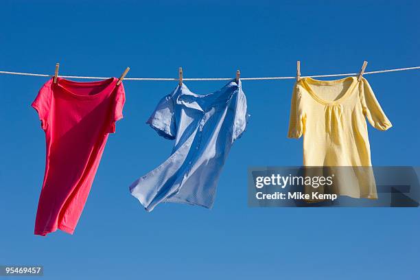 shirts on clothes line - wäscheleine stock-fotos und bilder