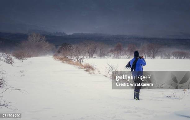 back view of photographer taking pictures in winter snow field park. - 岩手山 ストックフォトと画像