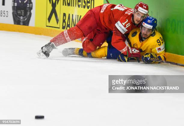 Belarus' Yevgeni Lisovets and Sweden's Mika Zibanejad fight for the puck during the 2018 IIHF Men's Ice Hockey World Championship match between...