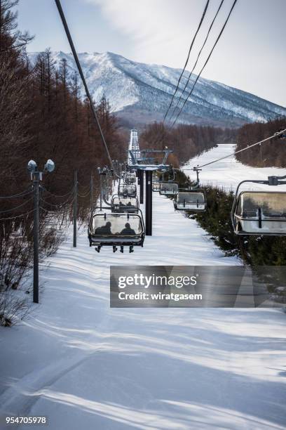 skiers are lifting on the ski lift at hachimantai ski resort. - 岩手山 ストックフォトと画像