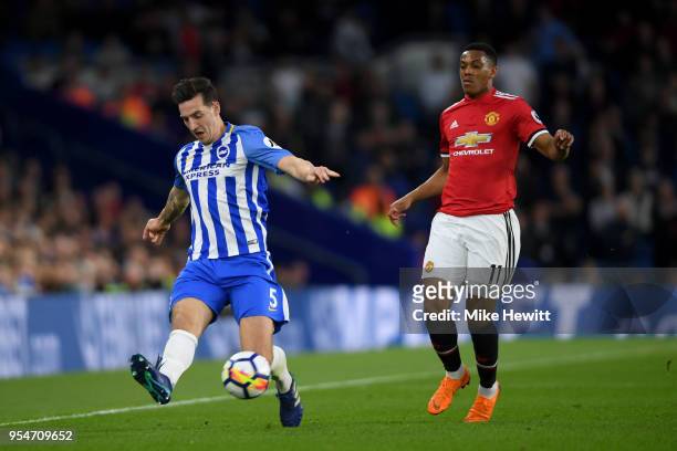 Lewis Dunk of Brighton & Hove Albion clears the ball under pressure from Anthony Martial of Manchester United during the Premier League match between...