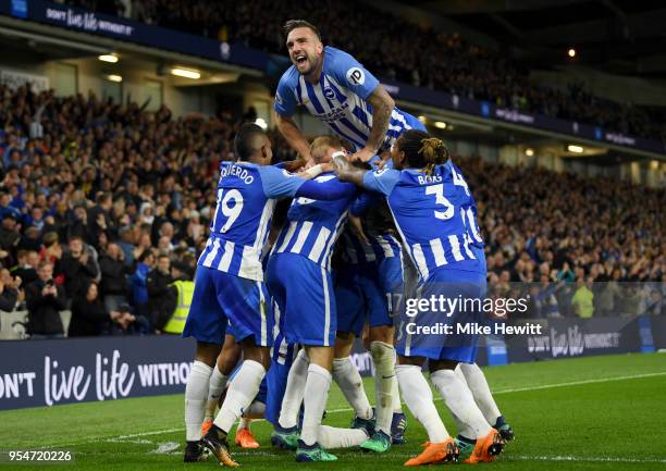 Shane Duffy of Brighton & Hove Albion jumps on his team-mates as they celebrate Pascal Gross scoring the opening goal during the Premier League match...