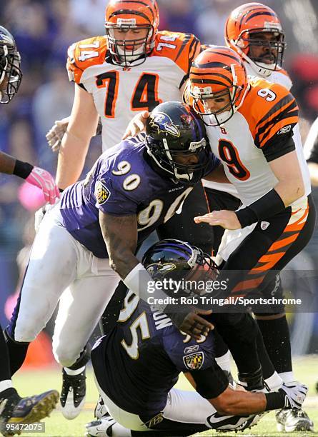 Carson Palmer of the Cincinnati Bengals is tackled by Trevor Pryce and Jarret Johnson of the Baltimore Ravens defense at M&T Bank Stadium on October...