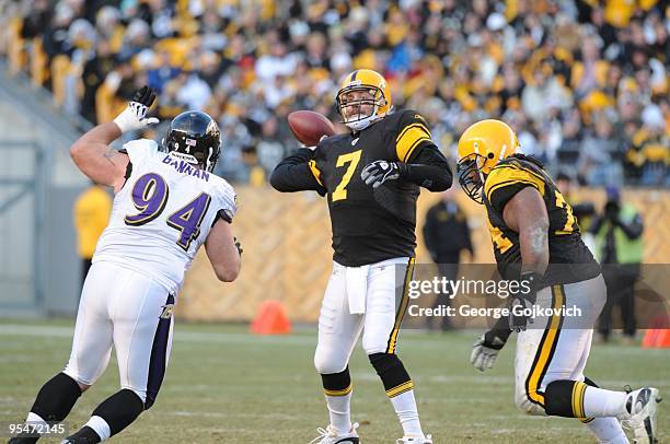 Quarterback Ben Roethlisberger of the Pittsburgh Steelers passes while under pressure from defensive lineman Justin Bannan of the Baltimore Ravens as...