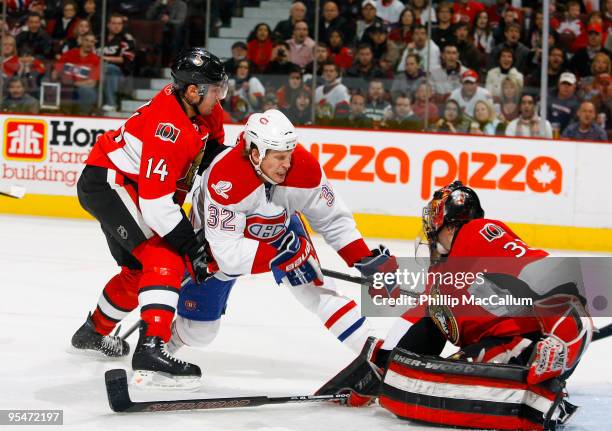 Pascal Leclaire of the Ottawa Senators makes a pad save while teammate Chris Campoli ties up Travis Moen of the Montreal Canadiens in a game at...