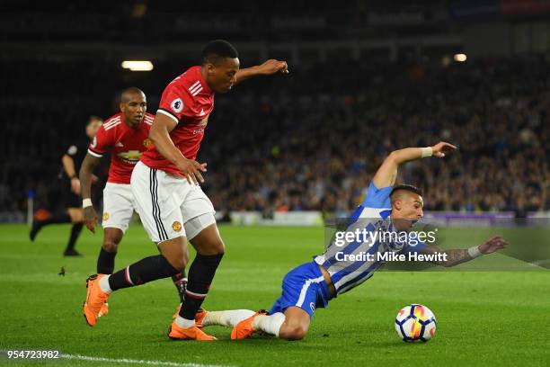 Anthony Knockaert of Brighton & Hove Albion goes down in the box as he is challenged by Anthony Martial of Manchester United during the Premier...