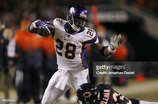 Adrian Peterson of the Minnesota Vikings runs the ball against Charles Tillman of the Chicago Bears in the first half at Soldier Field on December...