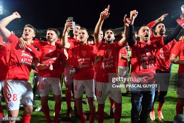 Nimes's players react after winning during the French L2 football match between Nimes and Ajaccio, on May 4, 2018 at the les Costieres Stadium in...