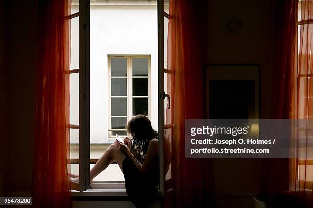a teenage girl  in paris orange window - joseph o. holmes stock pictures, royalty-free photos & images