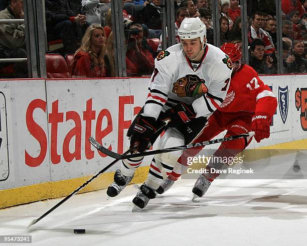 Brent Seabrook of the Chicago Blackhawks protects the puck from Patrick Eaves of the Detroit Red Wings during a NHL game at Joe Louis Arena on...