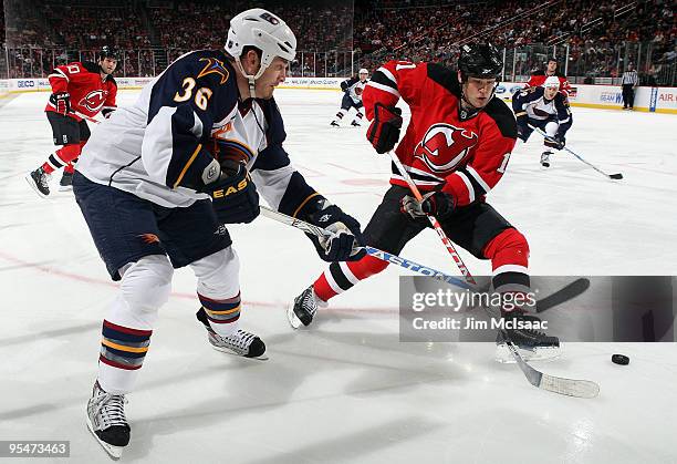 Eric Boulton of the Atlanta Thrashers plays the puck against Dean McAmmond of the New Jersey Devils at the Prudential Center on December 28, 2009 in...