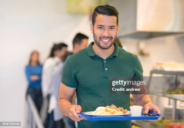 cheerful young fit man holding his tray at a buffet looking at camera smiling - man tray food holding stock pictures, royalty-free photos & images