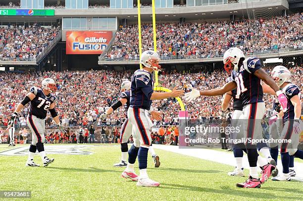 Tom Brady of the New England Patriots congratulates teammate Randy Moss the game against the Baltimore Ravens at Gillette Stadium on October 4, 2009...