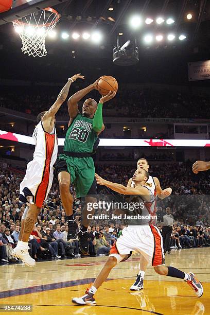 Ray Allen of the Boston Celtics shoots over Monta Ellis and Stephen Curry of the Golden State Warriors during an NBA game at Oracle Arena on December...