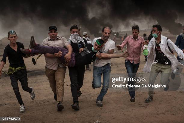 Wounded Palestinian protester is taken away during clashes with Israeli forces on May 4, 2018 in Khan Yunis, Gaza. Israeli troops fired live rounds...