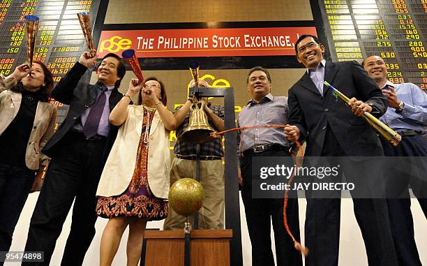 Officials of the Philippine Stock Exchange cheer as they ring the closing bell to signify the last trading of the year in Manila's financial district...