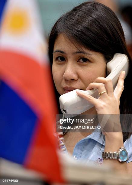 Trader talks on the phone on the trading floor of the Philippine Stock Exchange during the last trading day of the year in Manila's financial...