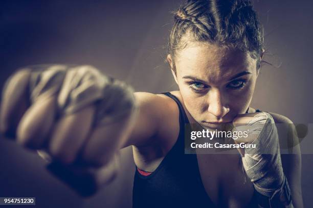 portret van de jonge vrouw fighter ponsen naar camera - female fist fights stockfoto's en -beelden