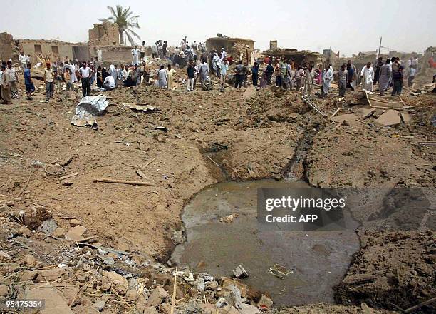 Iraqis gather around a crater caused by a truck bomb in Taza, some 30 kms south of in the northern city of Kirkuk, on June 20, 2009. Three men were...