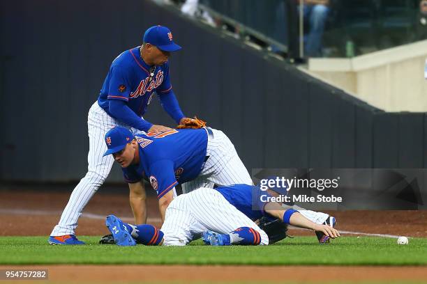 Brandon Nimmo, Jay Bruce and Asdrubal Cabrera of the New York Mets collide pursuing a double off the bat of Ian Desmond of the Colorado Rockies in...