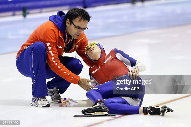 Dutch Marianne Timmer is helped by the team physical therapist Willem Kruithof after she fell during her 500 meter race at the ISU World Cup...