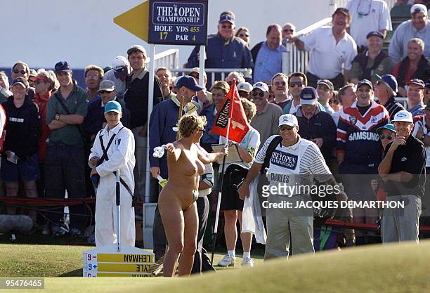 Woman streaker plays with flag on the 16th green after she invaded the Old Course at St. Andrews during the second round of the British Open...