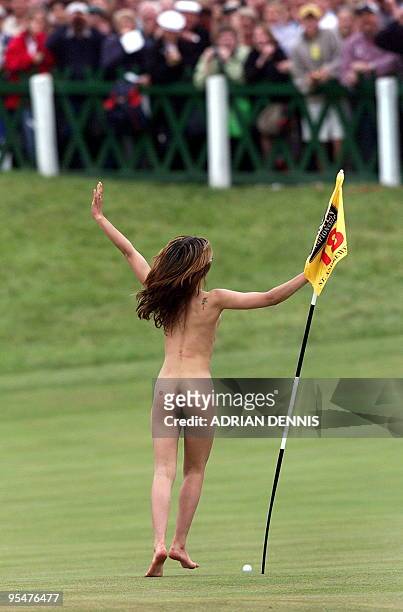 Woman streaker invades the 18th green to run around the flag just before the arrival of Tiger Woods onto the green on the Old Course at St. Andrews...
