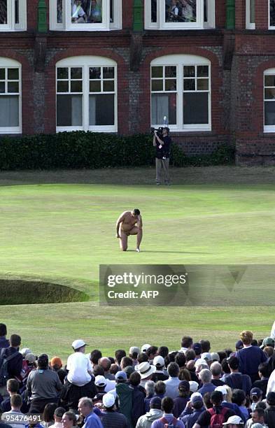 Male streaker strikes a pose on the 18th green in front of the clubhouse, 22 July 2001, just seconds after David Duval won the Open Golf Championship...