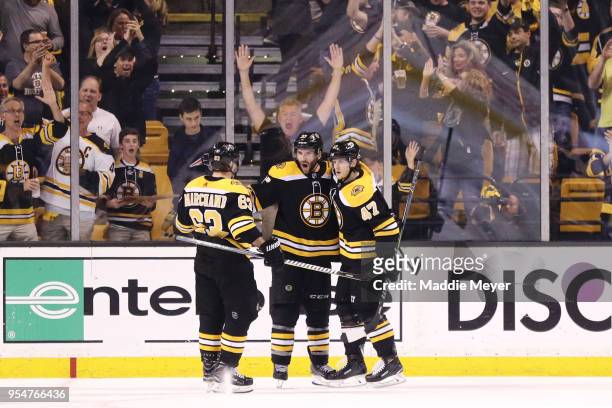 Patrice Bergeron of the Boston Bruins celebrates with Brad Marchand and Torey Krug after scoring against the Tampa Bay Lightning during the second...