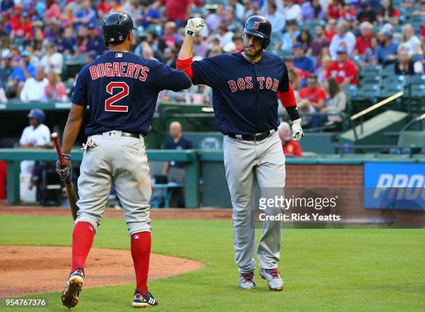 Xander Bogaerts of the Boston Red Sox congratulates J.D. Martinez for hitting a hits a solo home run in the first inning against the Texas Rangersat...