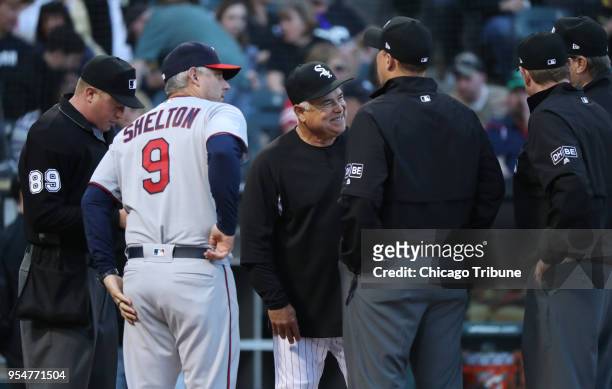 Chicago White Sox manager Rick Renteria, middle, and Minnesota Twins bench coach Derek Shelton meet with the umpiring crew before the first pitch at...