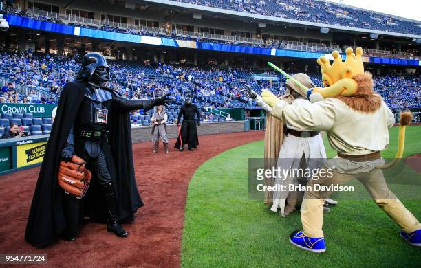 Characters dressed as Darth Vader, Luke Skywalker, and Sluggerrr do the "force choke" pose before the game between the Detroit Tigers and the Kansas...