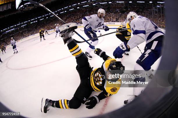 Cedric Paquette of the Tampa Bay Lightning checks Ryan Donato of the Boston Bruins into the boards during the third period of Game Four of the...