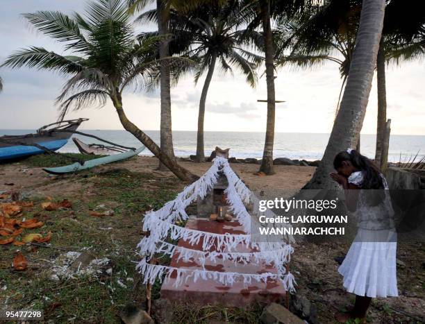 Sri Lankan relative commemorates the victims of the 2004 Asian tsunami with flowers and candles at Telwatta in Peraliya on December 26 on the fifth...