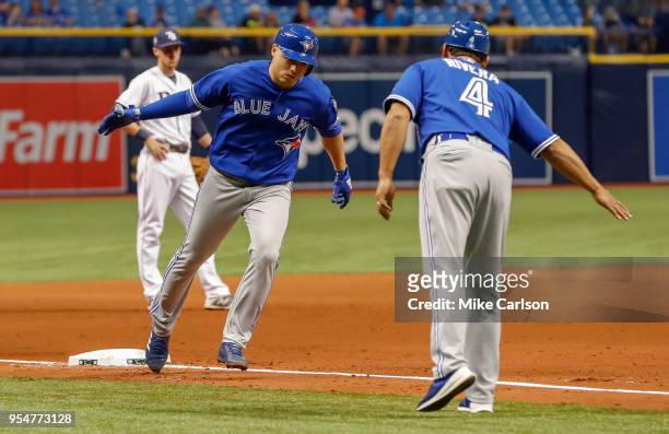 Aledmys Diaz of the Toronto Blue Jays is congratulated by third base coach Luis Rivera after his home run in the eighth inning of a baseball game...